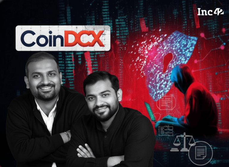 A man in a hoodie hunched over a laptop, with digital code and a lock icon in the background, symbolizing fraud.