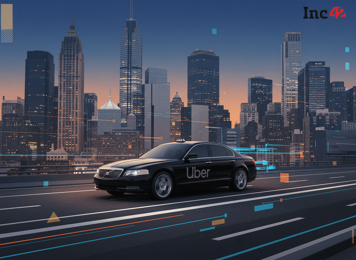 A sleek black Uber car drives on a multi-lane highway with a vibrant, illuminated city skyline in the background at dusk.