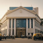 A grand, classical bank building with columns in a bustling Indian city, with people and yellow taxis moving.